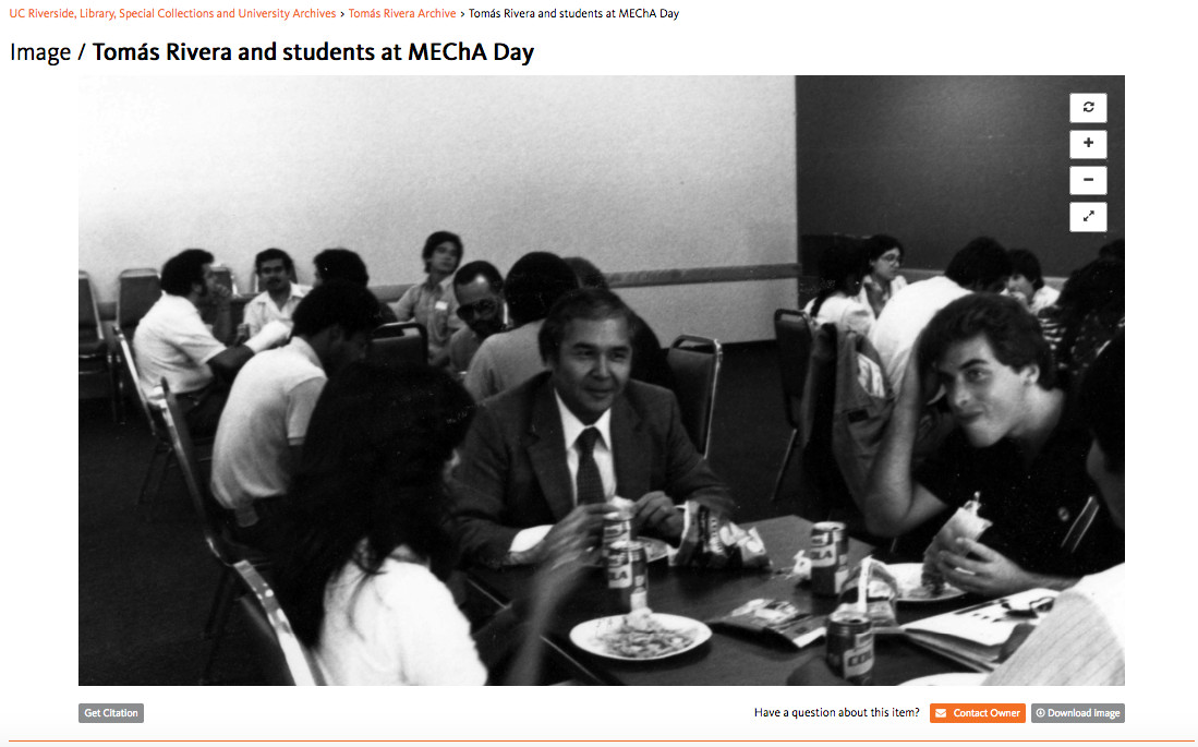 same image of Tomas Rivera eating lunch with students, shown in context on Calisphere with title 'Tomas Rivera and students at MEChA day